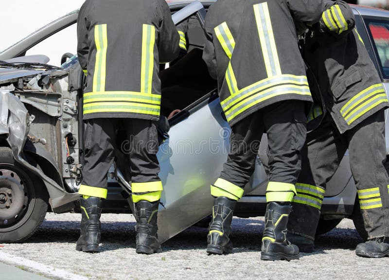 firemen remove the door of a destroyed car after a serious car accident to recover the injured motorist. firemen remove the door of a destroyed car after a serious car accident to recover the injured motorist