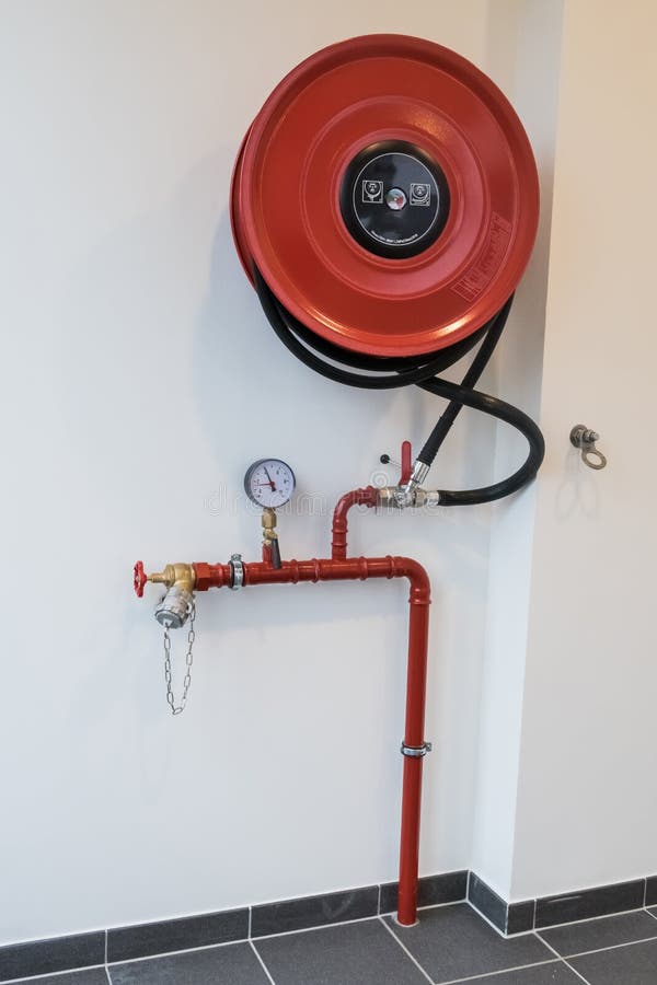 An fire hose hanging on the wall in an staircase. An fire hose hanging on the wall in an staircase