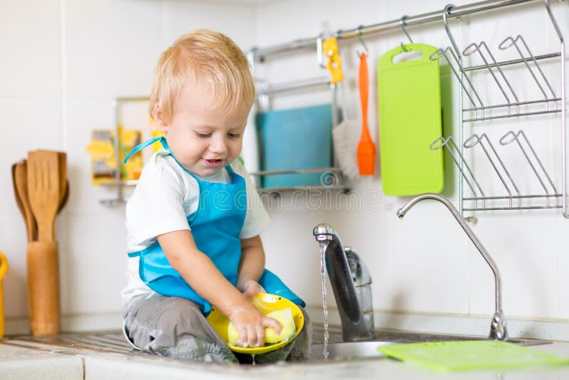 Cute child boy 2 years old washing up in kitchen. Cute child boy 2 years old washing up in kitchen