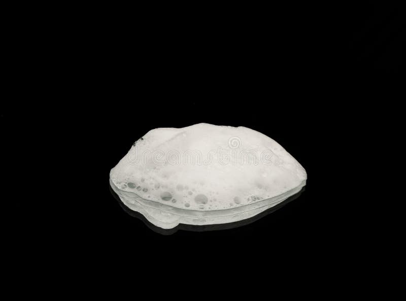 Soap foam on a dark background. Texture of white soap foam. Soap foam on a dark background. Texture of white soap foam.