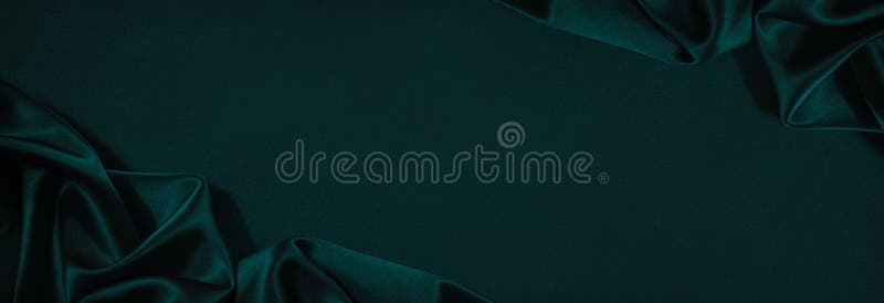 Dark blue green silk satin background. Beautiful soft folds on the smooth surface of the fabric. Luxury background with copy space for design. Wide banner. Top view. Flat lay. Dark blue green silk satin background. Beautiful soft folds on the smooth surface of the fabric. Luxury background with copy space for design. Wide banner. Top view. Flat lay.