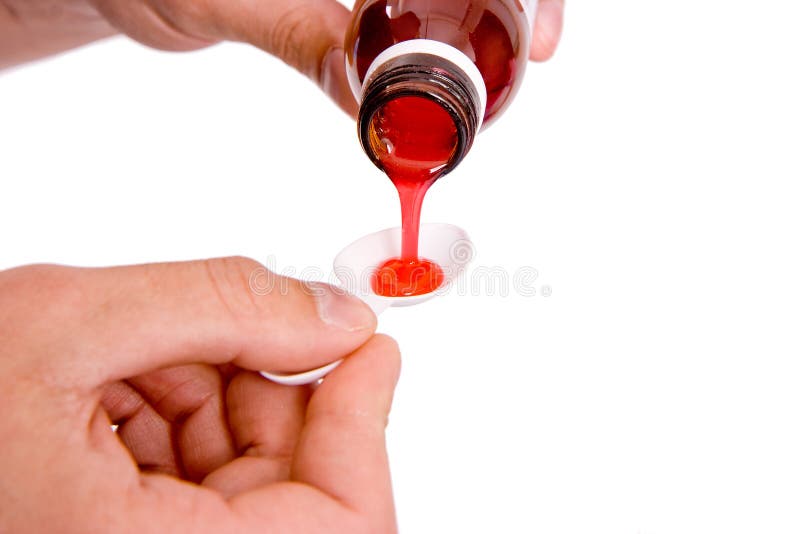 On a white background the hand pours children's mixture in a spoon. On a white background the hand pours children's mixture in a spoon