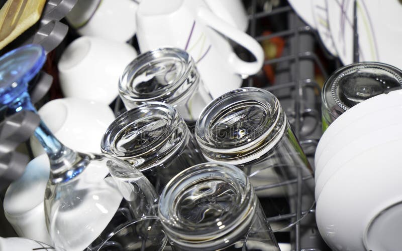 Freshly washed glasses and plates from the dishwasher ready to be cleared out. Freshly washed glasses and plates from the dishwasher ready to be cleared out