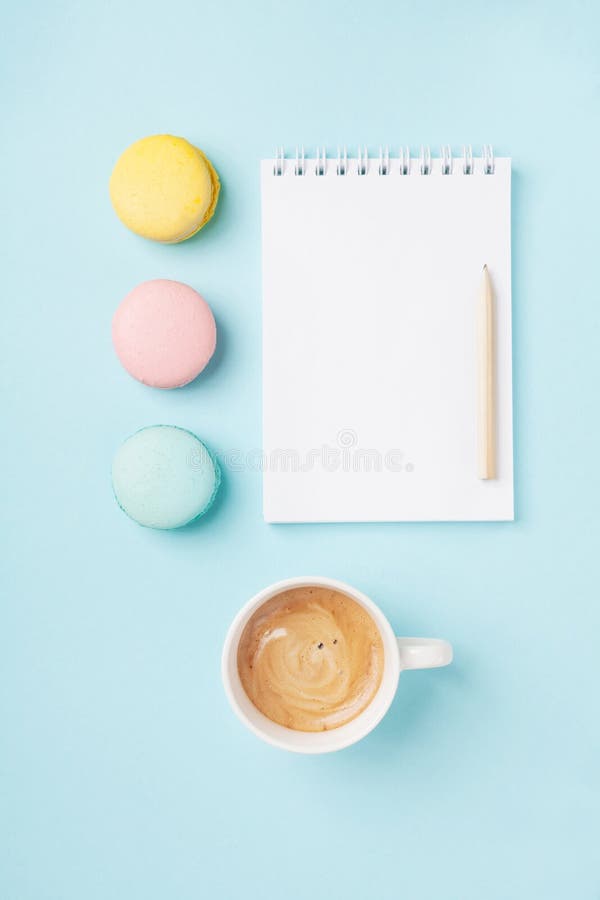 清洗笔记薄、咖啡和在蓝色桌面看法的五颜六色的macaron 舒适早晨早餐时尚舱内甲板位置 甜蛋白杏仁饼干 免版税图库摄影 清洗笔记薄、咖啡和在蓝色桌面看法的五颜六色的macaron 舒适早晨早餐时尚舱内甲板位置 甜蛋白杏仁饼干 免版税图库摄影