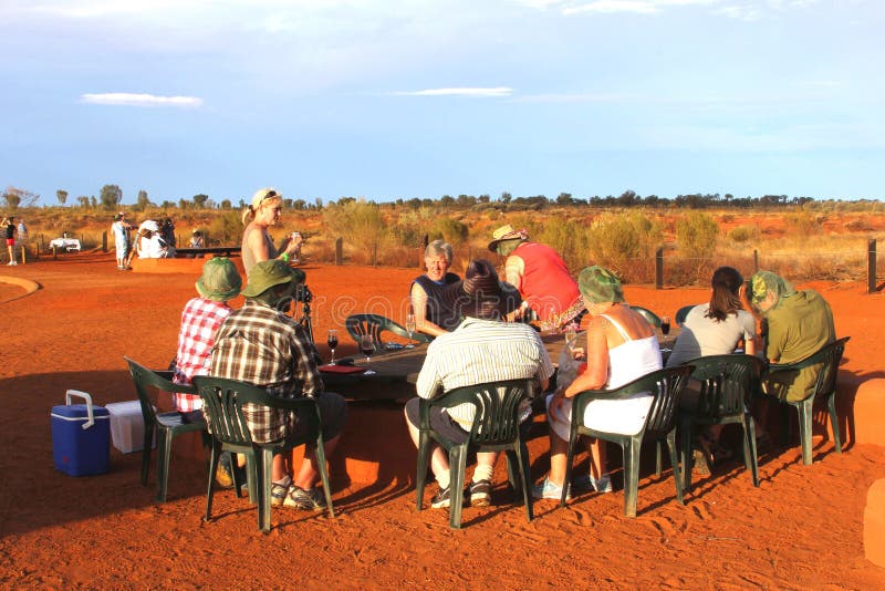 Tourists are enjoying a picknick with a glass of wine near Ayers Rock in Uluru Kata Tjuta national park in Northern Terrirory Australia. Tourists are enjoying a picknick with a glass of wine near Ayers Rock in Uluru Kata Tjuta national park in Northern Terrirory Australia