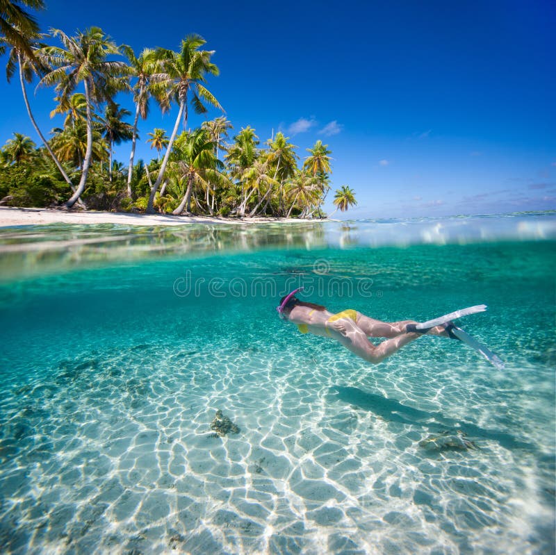 Woman swimming underwater in clear tropical waters in front of exotic island. Woman swimming underwater in clear tropical waters in front of exotic island