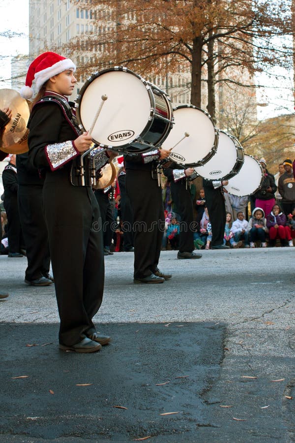 Atlanta, GA, USA - December 1, 2012: Bass drummers in a high school marching band bang their drums while perfomring in the annual Atlanta Christmas parade in downtown Atlanta. Atlanta, GA, USA - December 1, 2012: Bass drummers in a high school marching band bang their drums while perfomring in the annual Atlanta Christmas parade in downtown Atlanta.