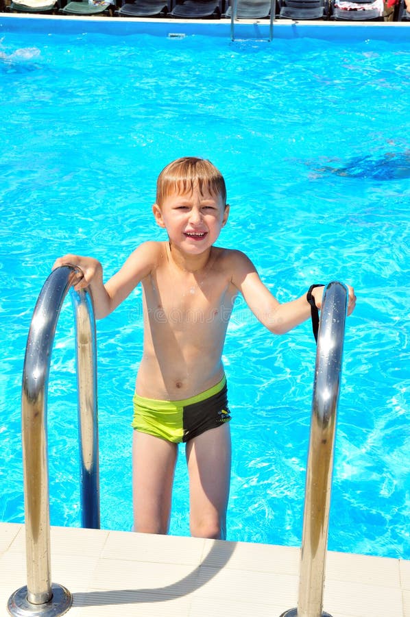 Little slim boy getting out from swimming pool. Little slim boy getting out from swimming pool