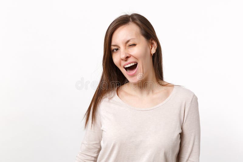 滑稽的快乐的微笑的眨眼睛的深色的年轻女人画象站立轻的衣裳的隔绝在白色背景 图库摄影 滑稽的快乐的微笑的眨眼睛的深色的年轻女人画象站立轻的衣裳的隔绝在白色背景 图库摄影