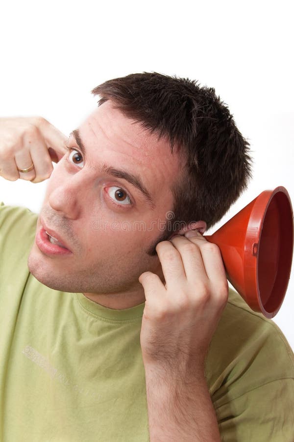 Young man, holding a funnel in one arm and finger in the other one, listening. Young man, holding a funnel in one arm and finger in the other one, listening