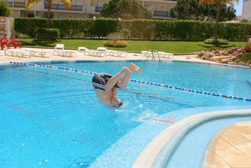 Boy dives into a pool at resort. Boy dives into a pool at resort