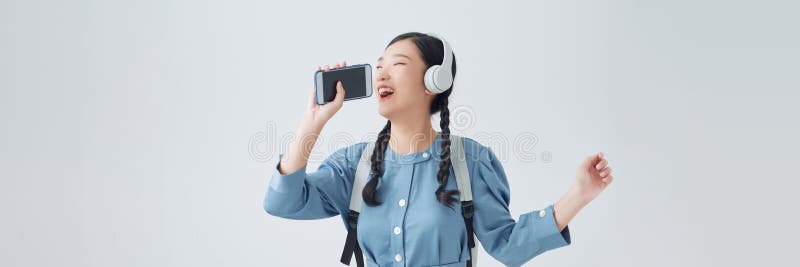 激动的亚洲女性用智能手机麦克风唱着自己最喜爱的歌 免版税库存图片