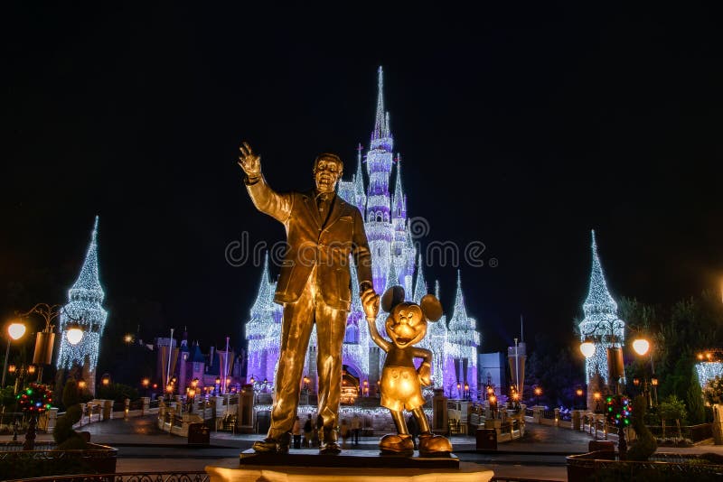 Disney`s Cinderella Castle, with Christmas icicles behind the statue of Walt Disnsy and Mickey Mouse. Disney`s Cinderella Castle, with Christmas icicles behind the statue of Walt Disnsy and Mickey Mouse