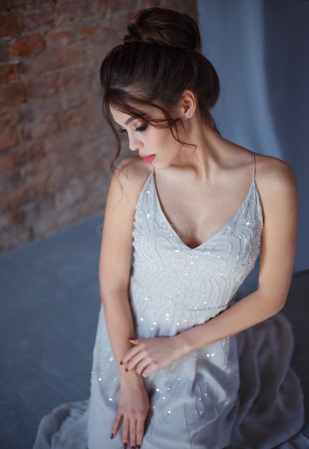 灰色的女孩,摆在照相机的晚礼服 与长的睫毛和多汁嘴唇的明亮的晚上构成 库存照片 灰色的女孩,摆在照相机的晚礼服 与长的睫毛和多汁嘴唇的明亮的晚上构成 库存照片
