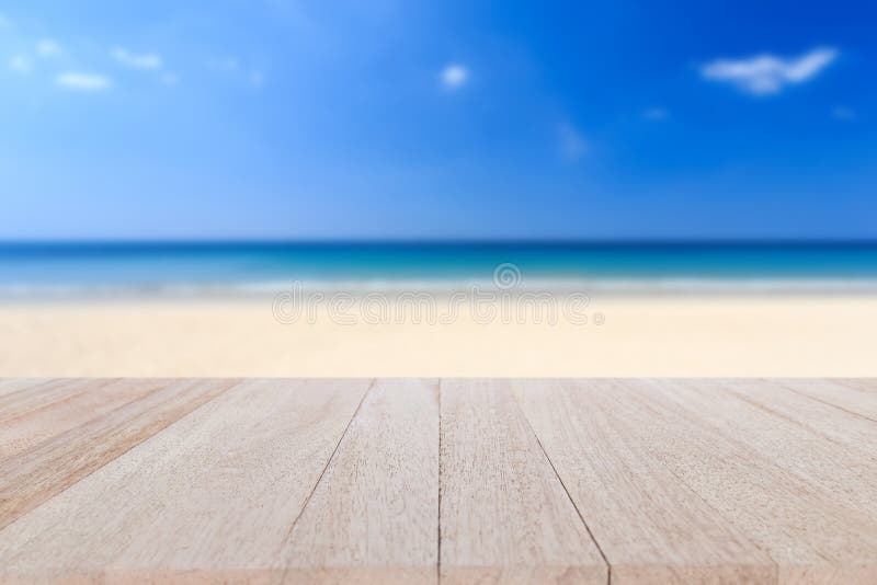 Close up top wooden table and blur of tropical beach background. Close up top wooden table and blur of tropical beach background