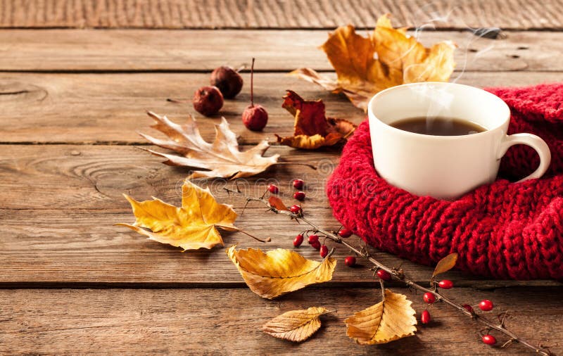 热的咖啡和秋叶在葡萄酒木头背景