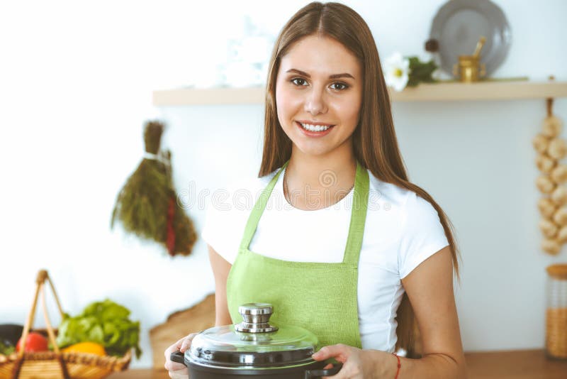 烹调汤的年轻愉快的妇女在厨房里 健康膳食、生活方式和烹饪概念 微笑的学生女孩 免版税库存照片 烹调汤的年轻愉快的妇女在厨房里 健康膳食、生活方式和烹饪概念 微笑的学生女孩 免版税库存照片