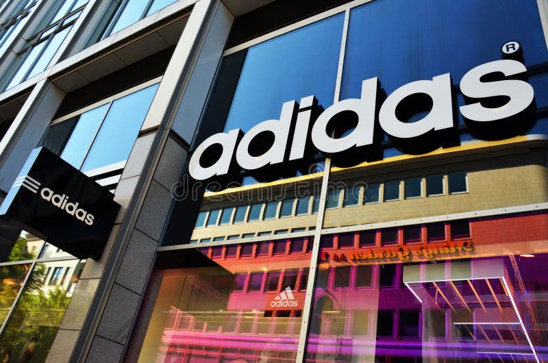 An Adidas store in berlin, Germany. Adidas is a German multinational corporation that designs and manufactures sports shoes, clothing and accessories. The company is based in Herzogenaurach, Bavaria, Germany. It is the holding company for the Adidas Group, which consists of the Reebok sportswear company, TaylorMade-Adidas golf company (including Ashworth), Rockport, 9.1% of FC Bayern Munich and Runtastic a former-Austrian fitness company. Besides sports footwear, Adidas also produces other products such as bags, shirts, watches, eyewear and other sports and clothing-related goods. Adidas is the largest sportswear manufacturer in Europe and the second biggest in the world, after Nike. Adidas was founded on 18 August 1949 by Adolf Dassler, following a family feud at the Gebrüder Dassler Schuhfabrik company between him and his older brother Rudolf. An Adidas store in berlin, Germany. Adidas is a German multinational corporation that designs and manufactures sports shoes, clothing and accessories. The company is based in Herzogenaurach, Bavaria, Germany. It is the holding company for the Adidas Group, which consists of the Reebok sportswear company, TaylorMade-Adidas golf company (including Ashworth), Rockport, 9.1% of FC Bayern Munich and Runtastic a former-Austrian fitness company. Besides sports footwear, Adidas also produces other products such as bags, shirts, watches, eyewear and other sports and clothing-related goods. Adidas is the largest sportswear manufacturer in Europe and the second biggest in the world, after Nike. Adidas was founded on 18 August 1949 by Adolf Dassler, following a family feud at the Gebrüder Dassler Schuhfabrik company between him and his older brother Rudolf.