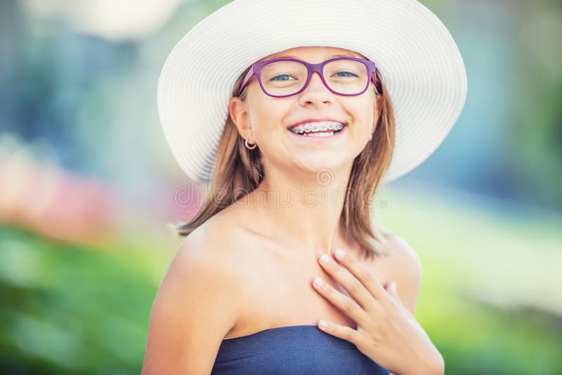 戴牙齿括号和眼镜的愉快的微笑的女孩 年轻逗人喜爱的白种人白肤金发的女孩佩带的牙括号和玻璃 库存照片 戴牙齿括号和眼镜的愉快的微笑的女孩 年轻逗人喜爱的白种人白肤金发的女孩佩带的牙括号和玻璃 库存照片