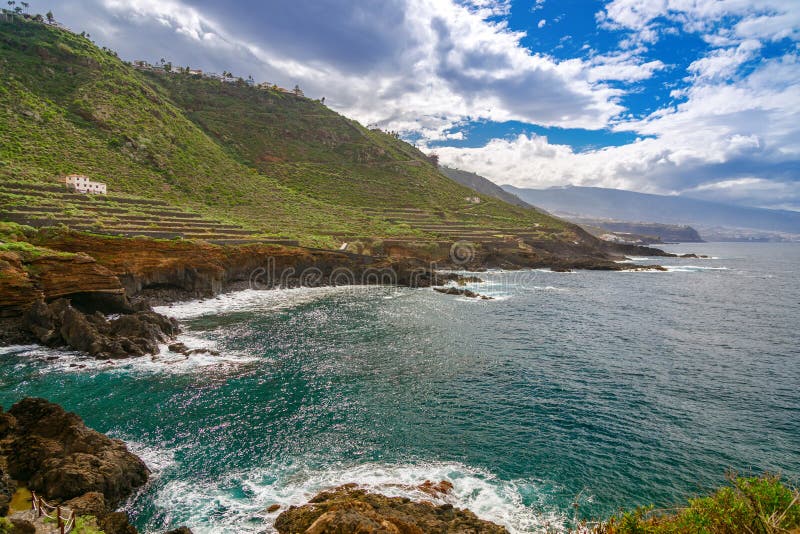 特内里费的Costa de El Sauzal海岸景观令人惊叹，拥有绿色山坡梯级斜坡，并设有崎岖的悬崖 免版税库存图片