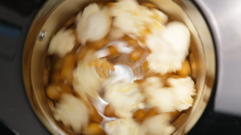 特写家庭爆米花机制作新鲜脆爆米花. 爆米花机或家用爆米花机 股票录像