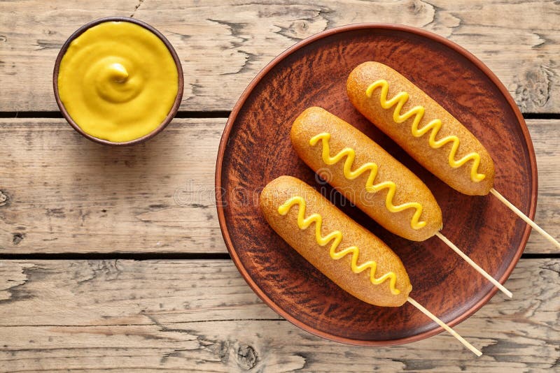玉米面热狗传统美国corndog街道速食油炸了热狗肉香肠快餐用黄色芥末 图库摄影