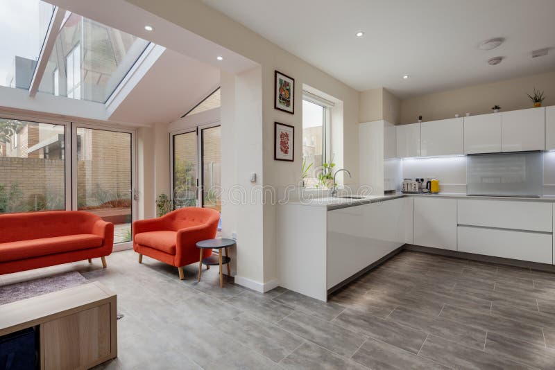 Trumpington, Cambridge, England - Feb 2 2019: Luxury modern contemporary fitted kitchen open plan to living area with bifold doors leading to courtyard garden. Trumpington, Cambridge, England - Feb 2 2019: Luxury modern contemporary fitted kitchen open plan to living area with bifold doors leading to courtyard garden