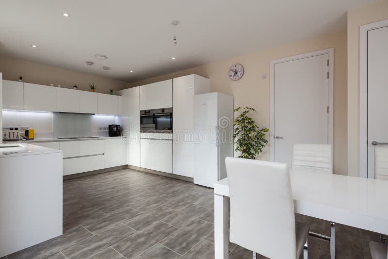 Trumpington, Cambridge, England - Feb 2 2019: Luxury furnished white modern contemporary fitted kitchen dining room. Trumpington, Cambridge, England - Feb 2 2019: Luxury furnished white modern contemporary fitted kitchen dining room