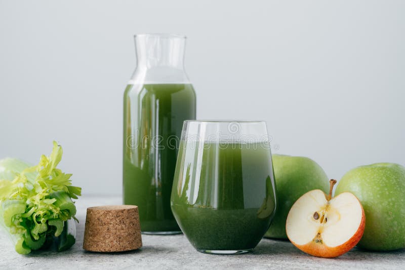 Green healthy celery and apple juice in glassware. Vegetable drink. Fresh smoothie isolated over white background. Organic beverage. Green healthy celery and apple juice in glassware. Vegetable drink. Fresh smoothie isolated over white background. Organic beverage