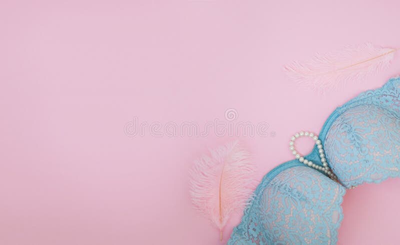 Blue bra with pearls and feathers on a pink background. Blue bra with pearls and feathers on a pink background