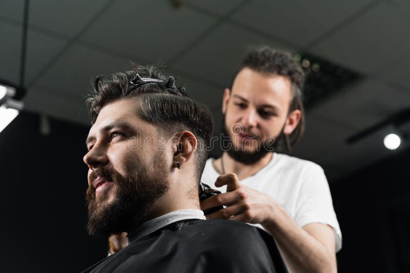 Low fade machine haircut for handsome bearded men in barbershop. Hair cut with a smooth transition. Low fade machine haircut for handsome bearded men in barbershop. Hair cut with a smooth transition