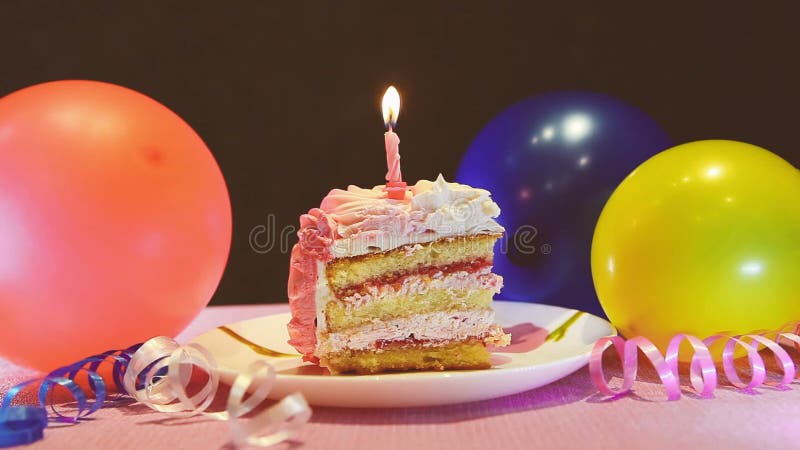 生日快乐蛋糕和灼烧的蜡烛，与气球的庆祝