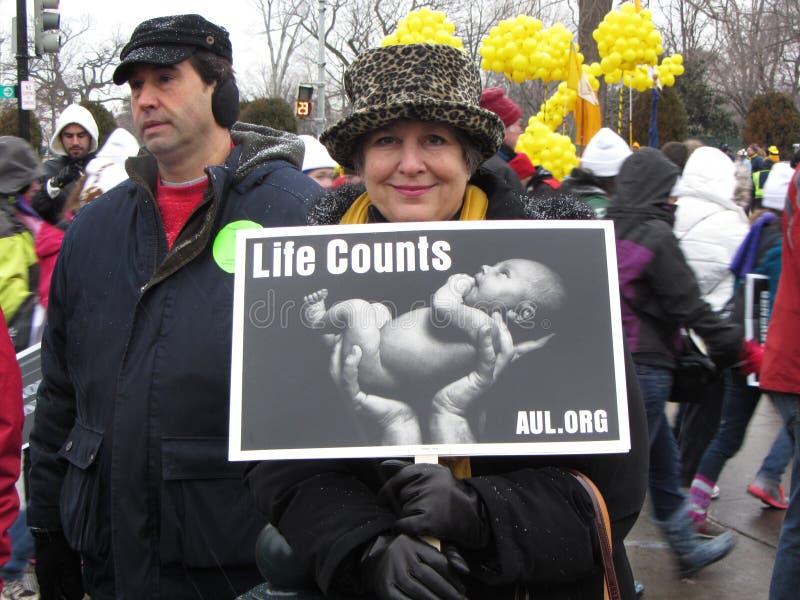 Photo of woman pro life protester in downtown washington dc near the supreme court on 1/25/13. This woman holds up a photo of a baby and is against the supreme court decision (roe versus wade) that allows a woman to choose whether or not she wants to bear a child. This the 40 year anniversary of the supreme court decision. Photo of woman pro life protester in downtown washington dc near the supreme court on 1/25/13. This woman holds up a photo of a baby and is against the supreme court decision (roe versus wade) that allows a woman to choose whether or not she wants to bear a child. This the 40 year anniversary of the supreme court decision.