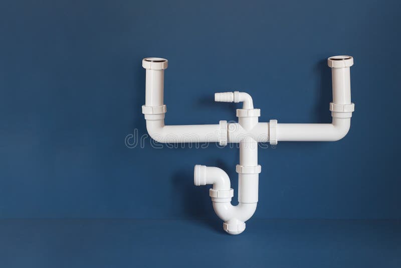 An isolated assembled double adjustable sink siphon for a 2-bowl sink with a horizontal outlet on a colorful blue studio background with copy space. Business and maintenance. An isolated assembled double adjustable sink siphon for a 2-bowl sink with a horizontal outlet on a colorful blue studio background with copy space. Business and maintenance