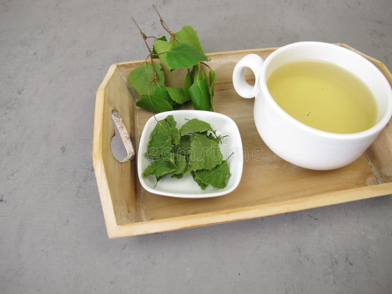用小托盘上的桦树干做的草茶 库存图片