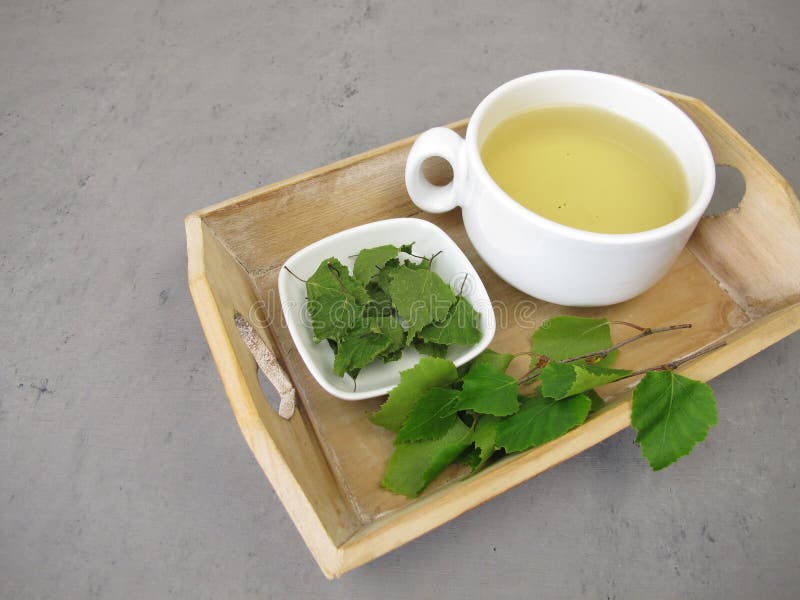 用小托盘上的桦树干做的草茶 图库摄影