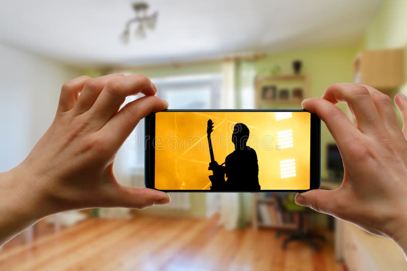 用智能手机在家观看网上音乐会 现场流音乐视频 免版税库存图片
