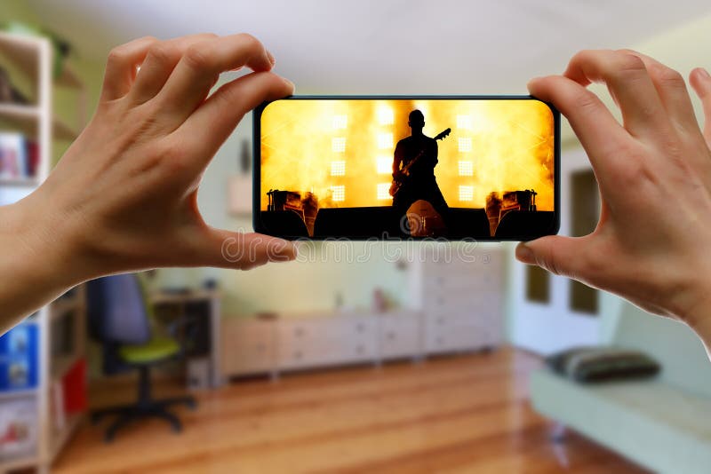 用智能手机在家观看网上音乐会 现场流音乐视频 库存图片