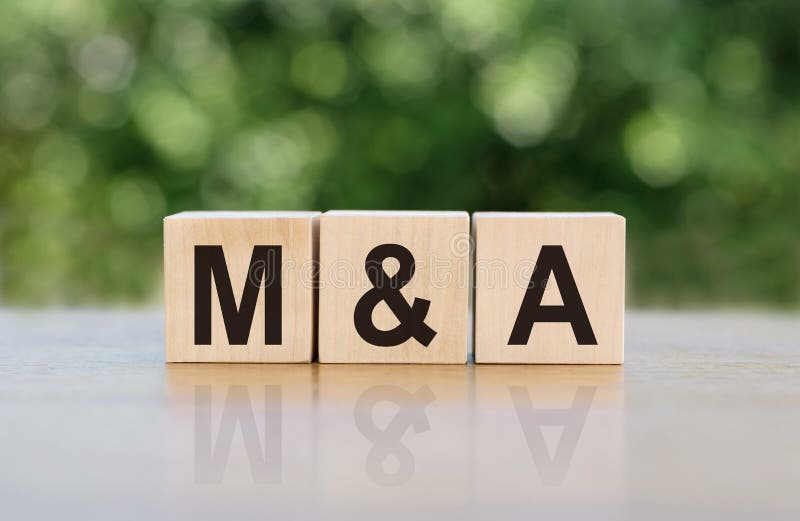 M&A Mergers and Acquisitions word written on wooden blocks. The text is written in black letters and is reflected in the mirror surface of the table. Business concept for your design. M&A Mergers and Acquisitions word written on wooden blocks. The text is written in black letters and is reflected in the mirror surface of the table. Business concept for your design