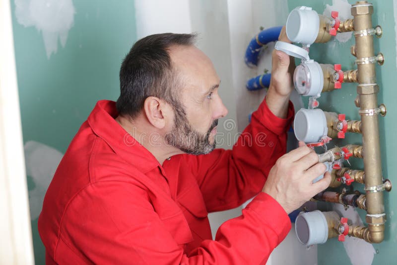 用水阀测量管道的人 库存照片