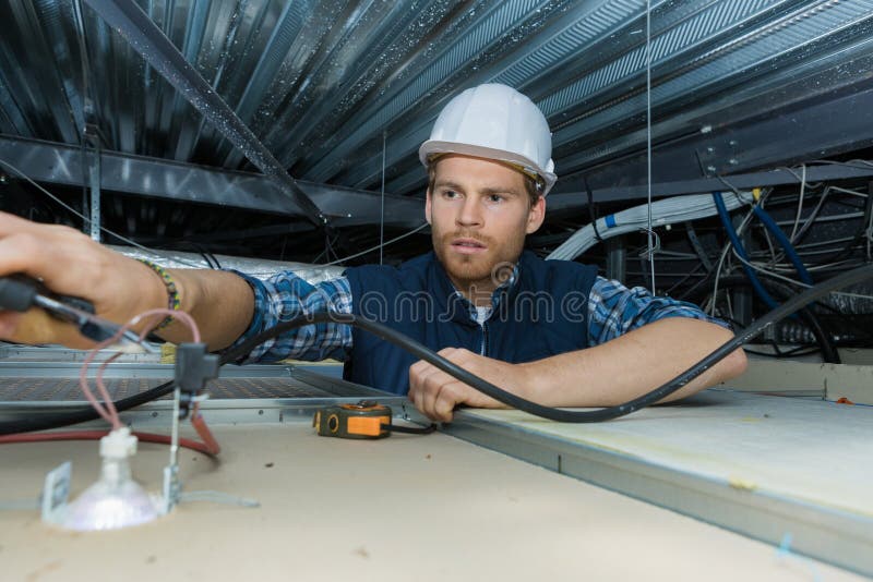 电工在工厂里处理电线 图库摄影