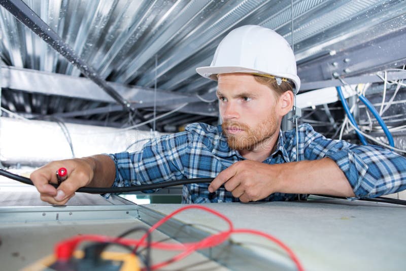 电工将灯具安装在天花板上 库存照片