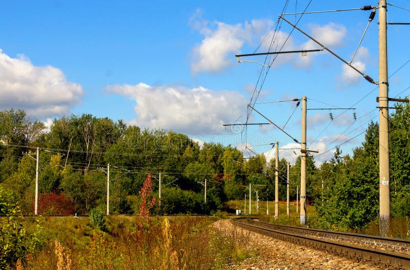 Asection of an electrified railway on a summer sunny day on the outskirs of a city. Asection of an electrified railway on a summer sunny day on the outskirs of a city