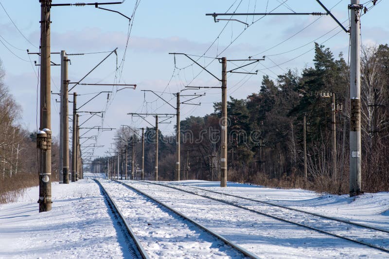 Two branches of the electrified railroad stretching into the distance. Electric poles along the railway. Selective focus. Two branches of the electrified railroad stretching into the distance. Electric poles along the railway. Selective focus