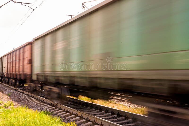 Train with freight wagons in motion on electrified railway in summer day period. Train with freight wagons in motion on electrified railway in summer day period