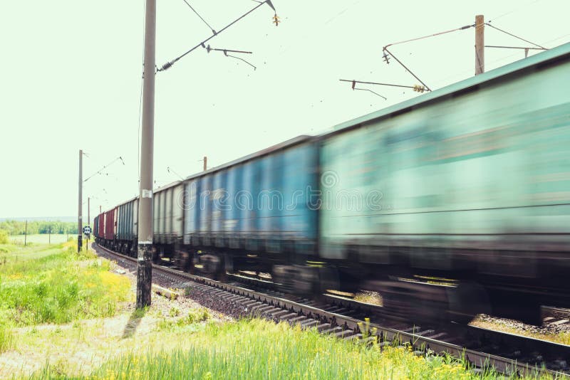 Train with freight wagons in motion on electrified railway in summer day period. Train with freight wagons in motion on electrified railway in summer day period