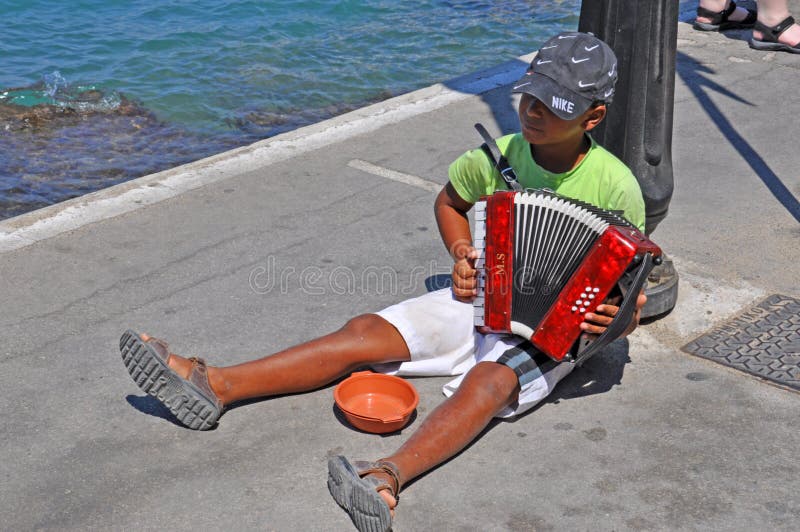Boy begging, playing accordion, Rhodes, Greece. Boy begging, playing accordion, Rhodes, Greece