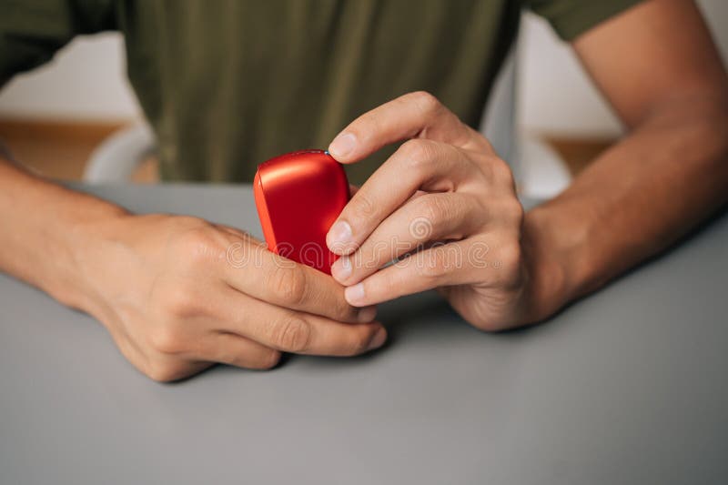 男性手持电子烟加热设备，代表一种具有潜力的替代尼古丁消费方式 库存照片