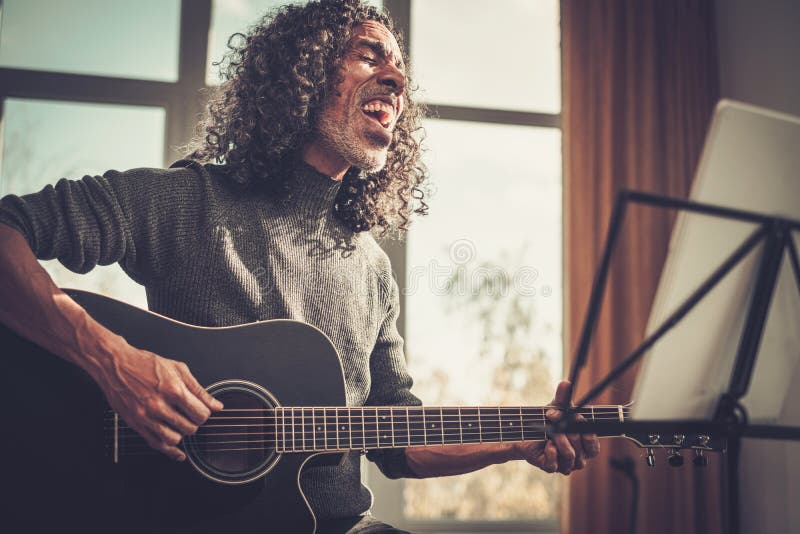 男性艺术家在工作室中情感地唱歌. 图库摄影