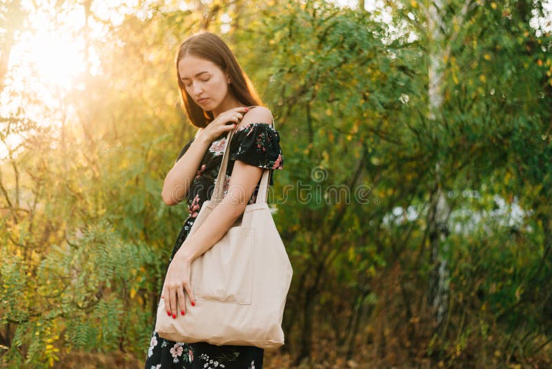 白种人女孩拿着日落的亚麻制顾客户外 零的废eco友好神志清楚 免版税库存图片 白种人女孩拿着日落的亚麻制顾客户外 零的废eco友好神志清楚 免版税库存图片